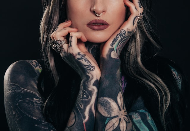 Woman displaying blackout sleeve tattoos