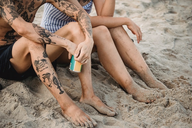 Tattooed man and woman relax at the beach