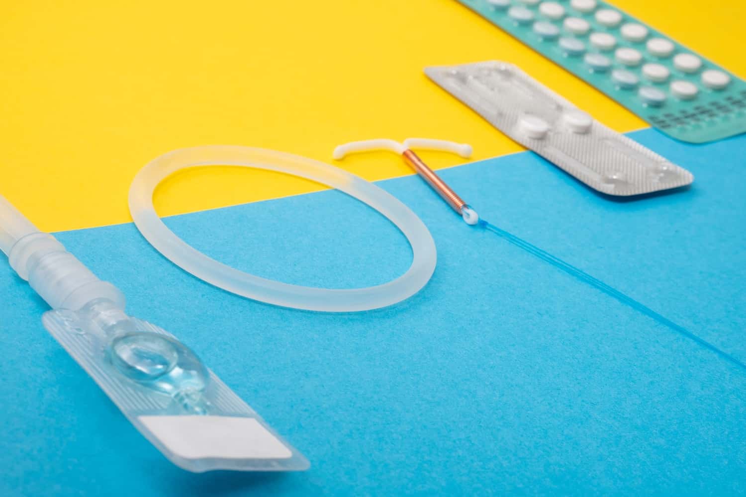 various types of birth control on a yellow and blue background