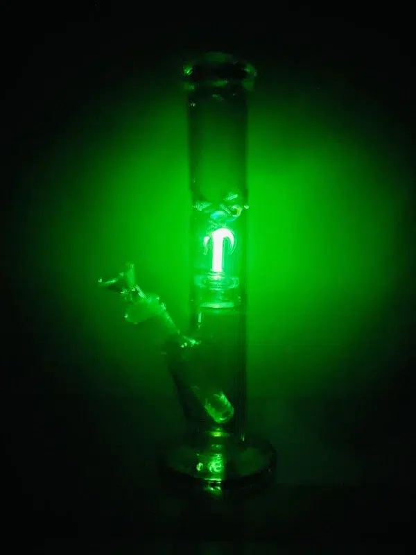 glass straight tube bong in dark with glow in the dark anchor design and circular green aura around