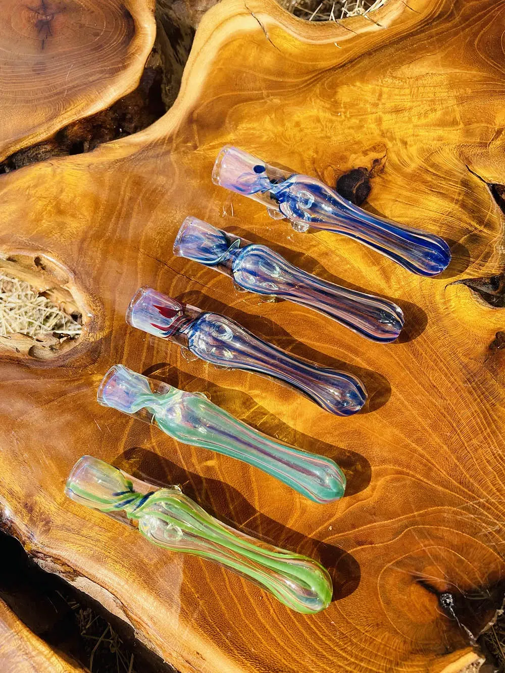 five chillum pipes with swirl pattern displayed on wooden table