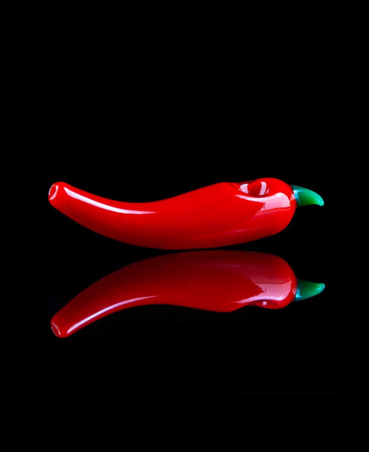 chili pepper pipe with reflection on table