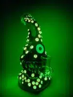 monster bong with many glowing eyes and green glow surrounding in the dark