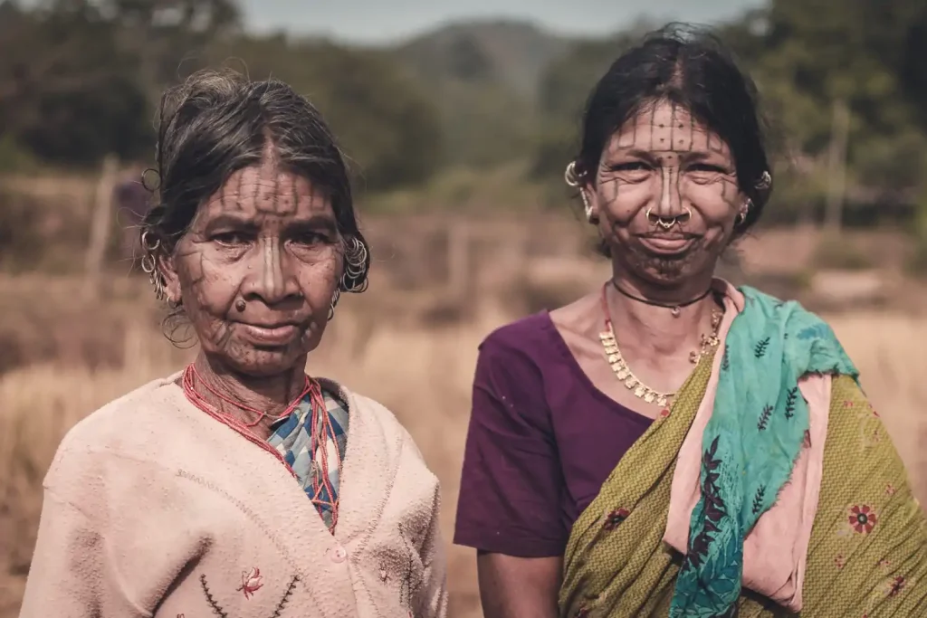 Two women sport traditional tribal dots and dashes tattoos on their faces