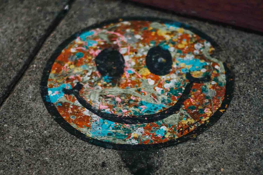 smiley face graffiti on pavement positive psychology