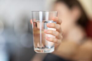 someone holding up a glass of water