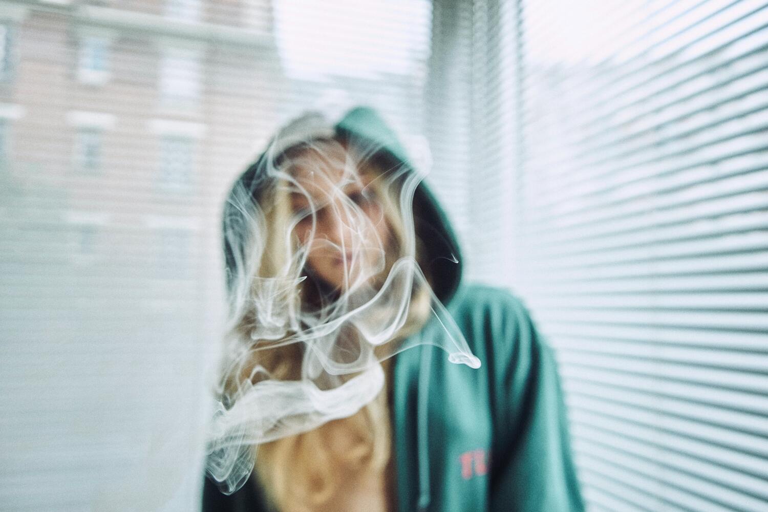 woman smoking weed and surrounded by a cloud of smoke