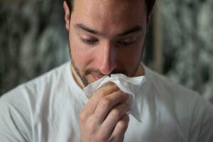 man blowing his nose