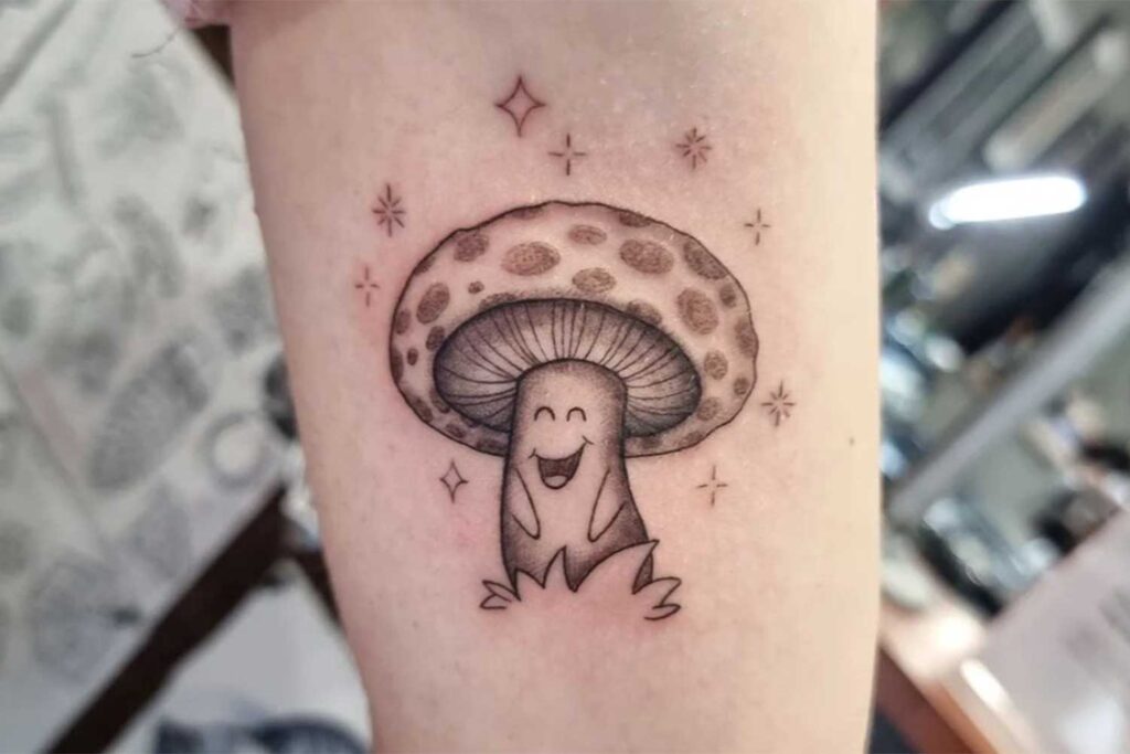 cute small mushroom tattoo smiling with stars surrounding