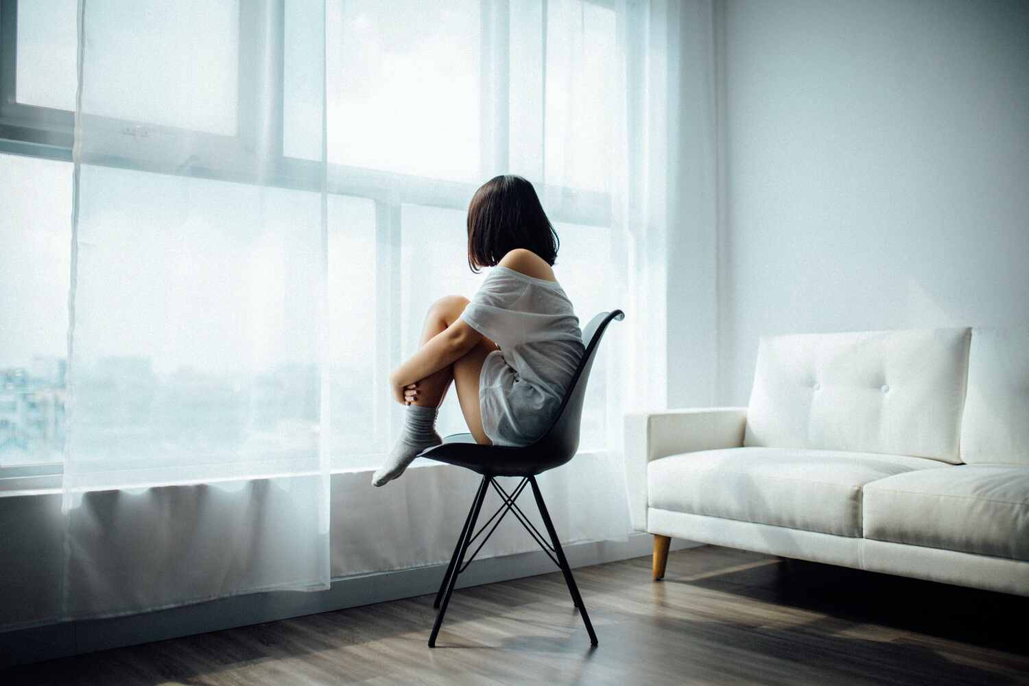 woman sitting on a chair looking out a window