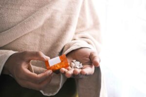 someone pouring pills from a bottle into their hand