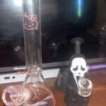 hello kitty bong and scream dab rig on wooden table in front of tv