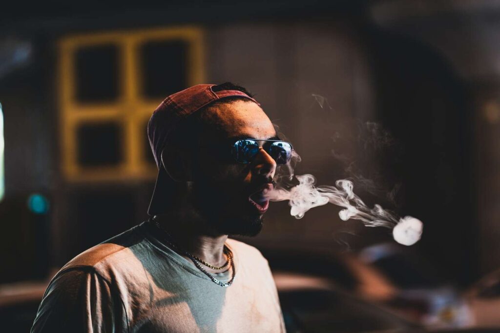 man blowing out smoke
