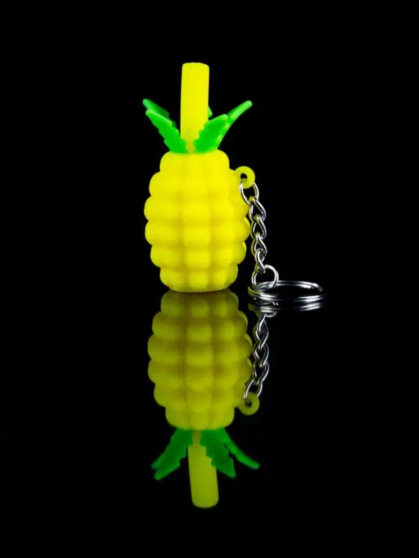 pineapple pipe keychain on black table