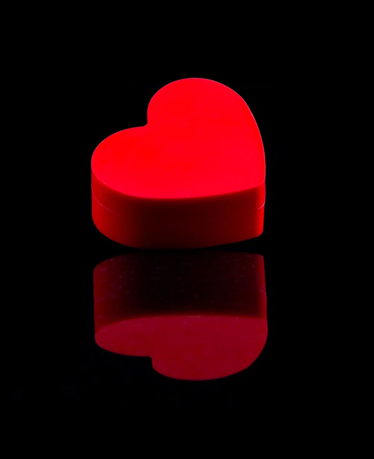 heart dab container in red on black table