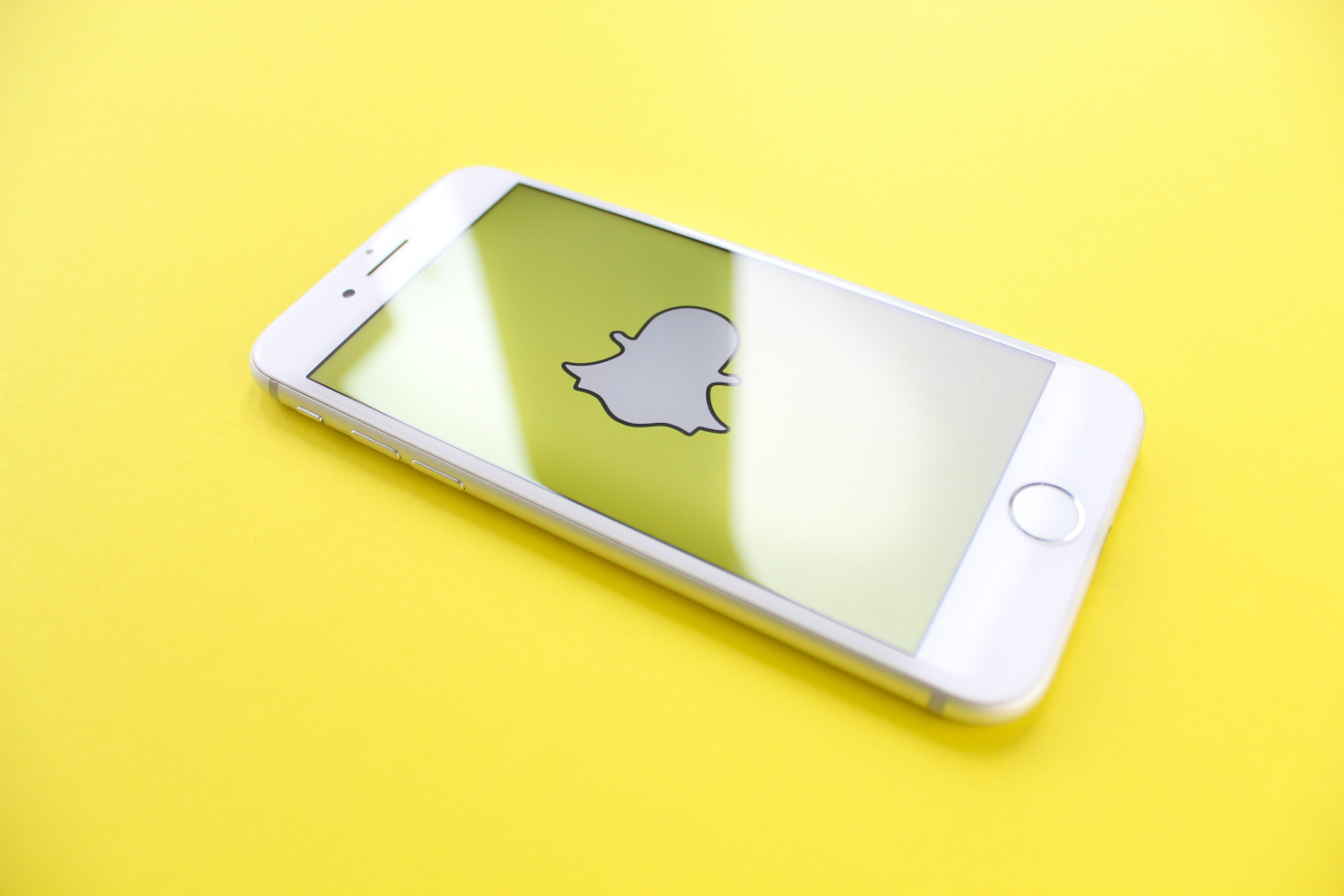 snapchat logo on phone on yellow table