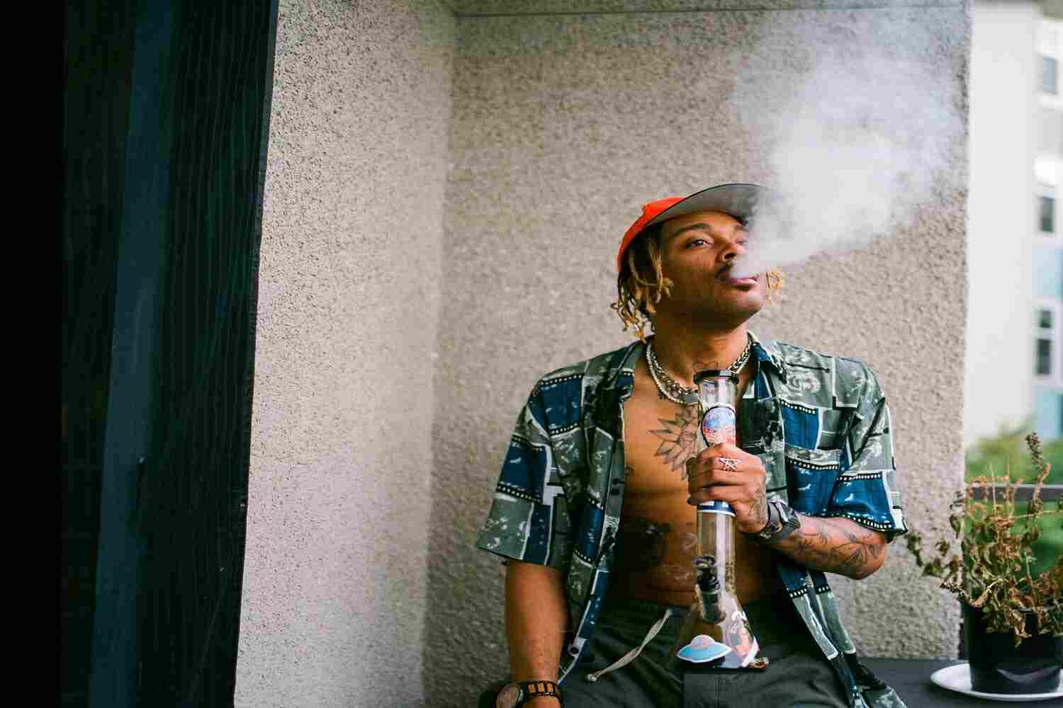 man smoking out of a bong