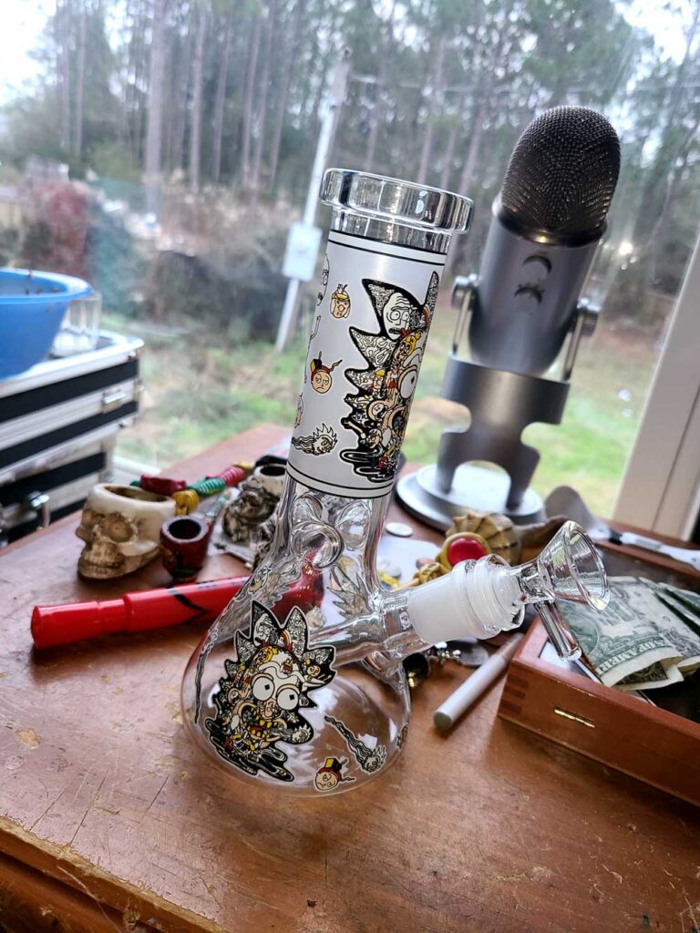 rick and morty bong on table with mic and other smoking accessories