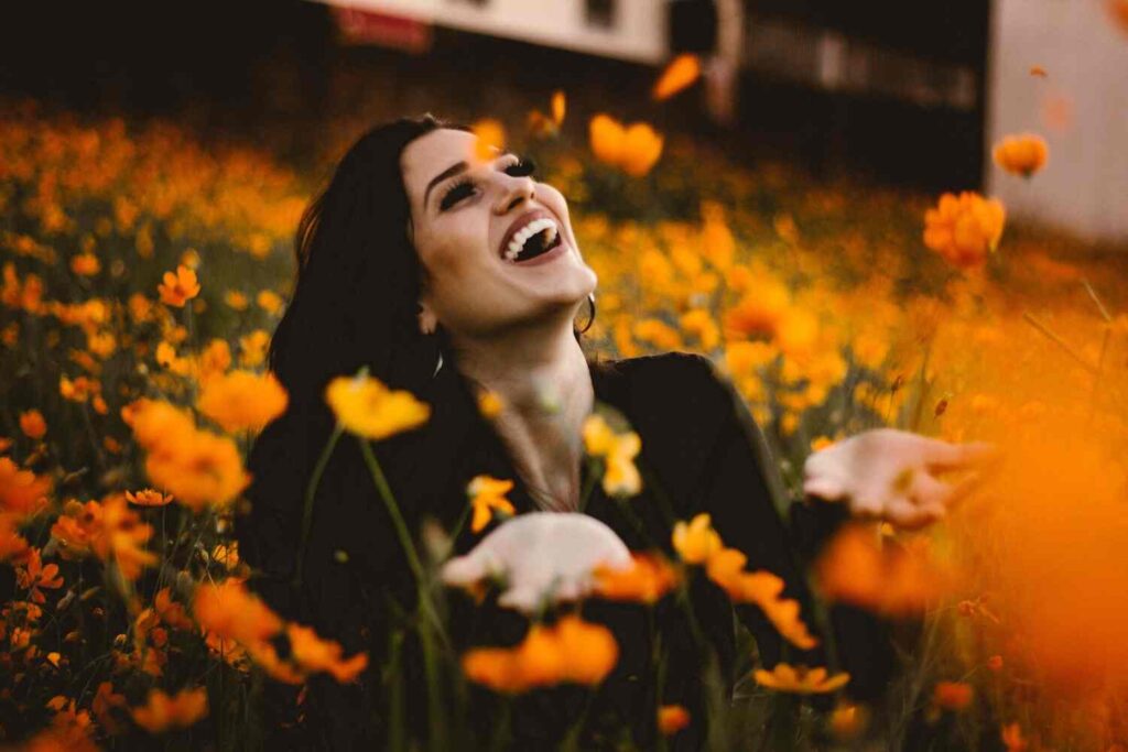 happy woman in a field of yellow flowers