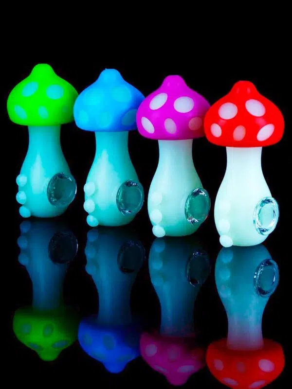 glow in the dark mushroom pipes lined up on black table