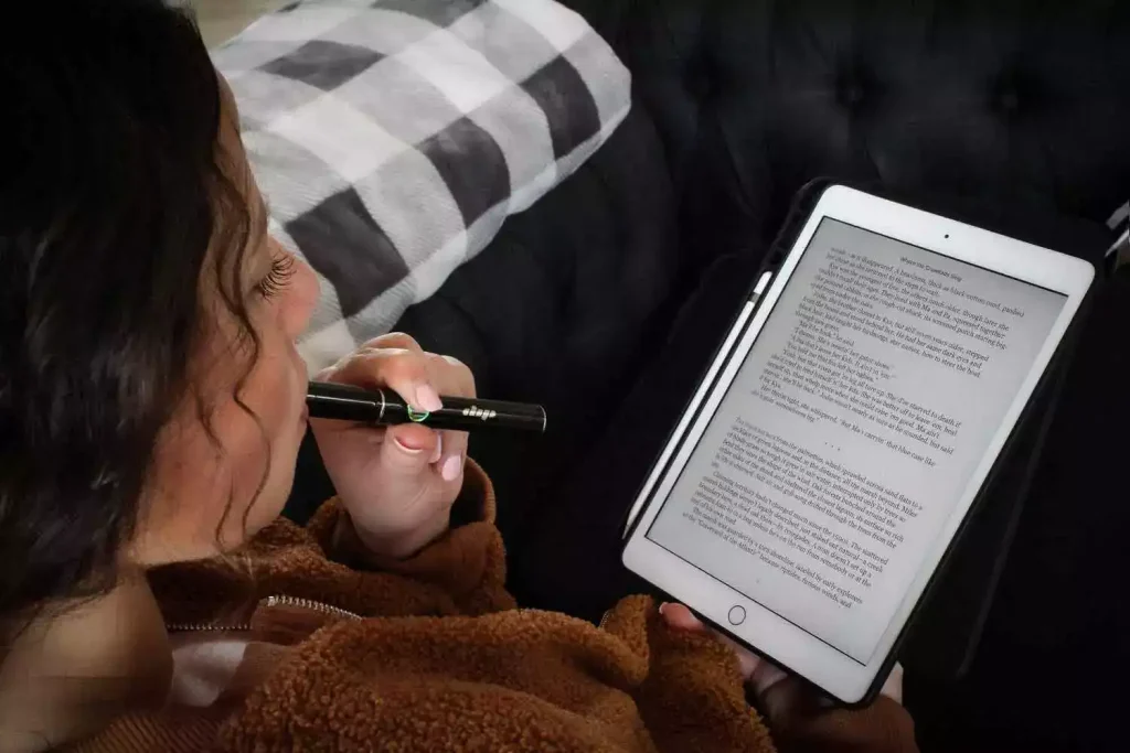 woman microdosing weed while reading a tablet
