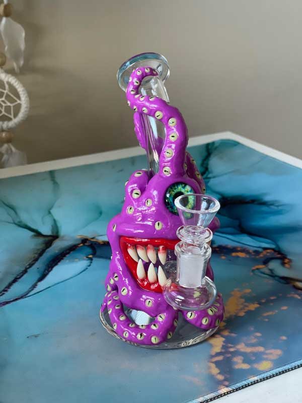 cyclops monster bong with fangs on blue marble table
