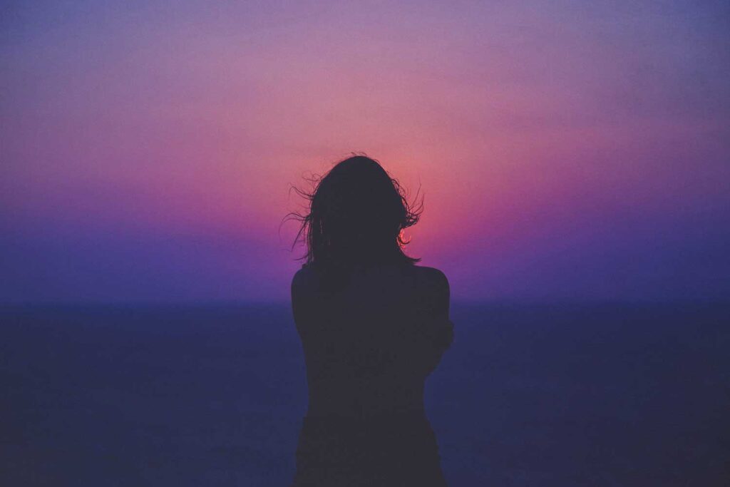 depressed woman looking at sunset