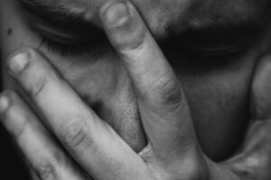 man with food poisoning holding his face