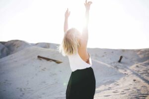 woman excited with hands in the air in the desert